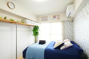 東京的住宿－SC Kameari 1103，一间卧室配有一张带蓝色床单的床和一扇窗户。