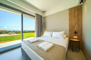ein Schlafzimmer mit einem Bett und einem großen Fenster in der Unterkunft ISKIOS Premium in Agia Marina + 28 Fotos