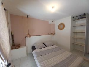 ein kleines Schlafzimmer mit einem Bett in einem Zimmer in der Unterkunft Le cosy in Clermont-lʼHérault