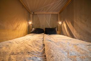 Un dormitorio con una cama con dos almohadas encima. en Lodge Holidays - Les 3 Cantons, en Saint-Antonin
