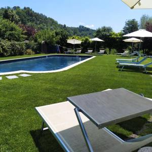 a picnic table in the grass next to a swimming pool at Il Gelso in Montopoli in Val dʼArno