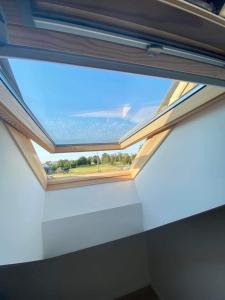 a skylight in a white room with a window at Cozy and new apartment , 5km Palanga to the center. in Vydmantai