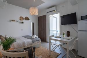 - une chambre avec un lit, une table et un bureau dans l'établissement Orchid's Cozy Apartment in Larnaca, à Larnaka