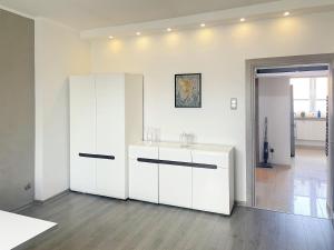 una cocina con armarios blancos en una habitación en Apartament Pyskowice Centrum, en Pyskowice