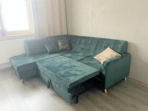 a green couch with two pillows on it in a living room at Apartament Pyskowice Centrum in Pyskowice