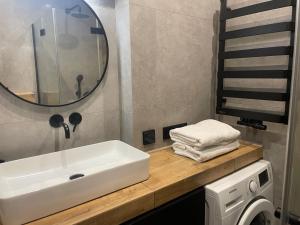 een badkamer met een wastafel en een wasmachine bij Apartament Pyskowice Centrum in Pyskowice