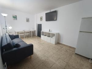 een woonkamer met een bank en een tv bij Beach House Roda de Bera in Roda de Bará