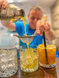 a man is pouring orange juice into glasses at TUI Blue Kalamota Island - All Inclusive in Dubrovnik