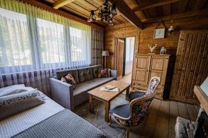 um quarto com uma cama, um sofá e uma mesa em Zacisze Pod Reglami em Zakopane