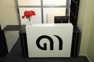 a white and black sign with a vase of red flowers at Galaxy Motel Kampala in Kampala