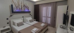 a small bedroom with two beds and a tv at olivegrove in Sidari