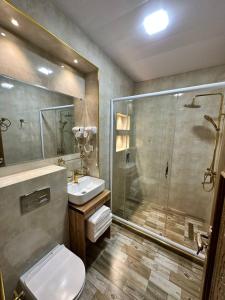 y baño con ducha, aseo y lavamanos. en AL-HAYAT, en Bukhara