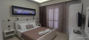 a bedroom with a bed with a tv on the wall at olivegrove in Sidari