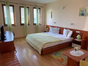 a bedroom with a large bed in a room with windows at Guest House Golden Flake 4km from Bolata beach in Bŭlgarevo +37 photos