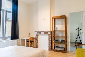 a bedroom with a mirror and a bed and a desk at Le Cerf Vert in Dinant