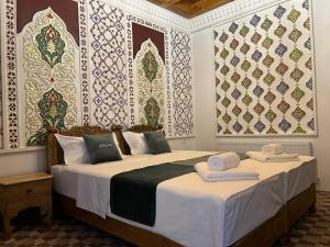 a bedroom with two beds with towels on them at AL-HAYAT in Bukhara