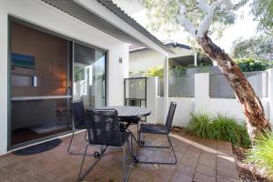 a patio with a table and chairs in front of a house at Luxury Modern Escapia in Fremantle