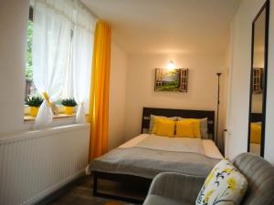 ein Schlafzimmer mit einem Bett mit gelben Kissen und einem Fenster in der Unterkunft Casa JOY in Râșnov