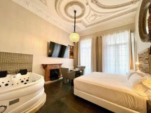 Schlafzimmer mit einem Bett, einer Badewanne und einem Kamin in der Unterkunft Hotel Boutique Adealba Badajoz in Badajoz