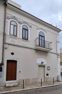 ein weißes Gebäude mit Balkon darüber in der Unterkunft Happy b&b in Torre Maggiore