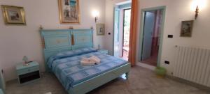a bedroom with a blue bed with a pink towel on it at Dimore Gemini Rooms in Gemini
