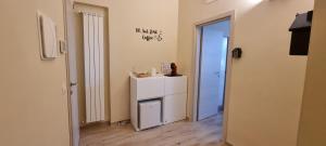 Zimmer mit einem kleinen weißen Kühlschrank und einer Tür in der Unterkunft Happy b&b in Torre Maggiore