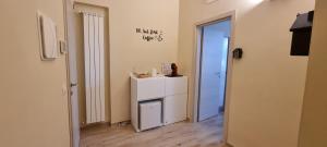 a room with a small white refrigerator and a door at Happy b&b in Torre Maggiore