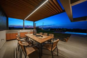 eine Küche und ein Esszimmer mit Tisch und Stühlen in der Unterkunft ISKIOS Premium in Agia Marina