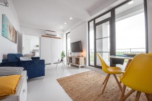 a living room with a blue couch and a yellow chair at Serenity by Oxygen Residence in Neptun