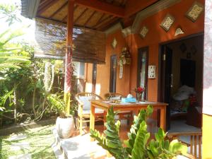 une terrasse couverte d'une maison avec une table et des chaises dans l'établissement Cegeng Lestari Guesthouse, à Sidemen