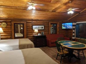 a bedroom with two beds and a table and a couch at Teton Court Motel in Pinedale