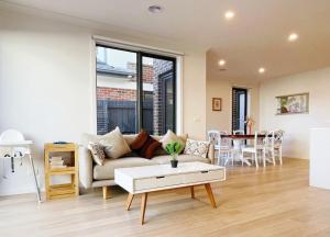 a living room with a couch and a table at Casey Green Townhouse by GoodLive in Narre Warren