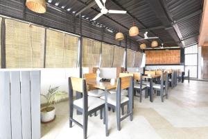 a dining room with tables and chairs and windows at White Town By Ashoka Group in Udaipur