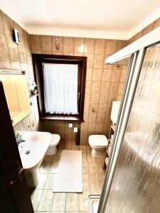 a bathroom with a sink and a toilet and a window at Villa Tisot in Siror