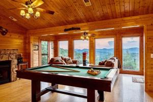 a living room with a pool table in a cabin at Panorama Mountain View Cabin, Less than 10 miles from Gatlinburg and Dollywood, Dog Friendly, 6 Bedrooms Sleeps 17, Fire Pit, HotTub, Washer Dryer, Fully loaded Kitchen, GameRoom with a TV, Pool Table, Arcade, Air Hockey, and Foosball in Sevierville