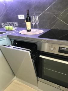 a bottle of wine sitting on top of a kitchen counter at Cosy studio apartment in Budva with sea view in Budva