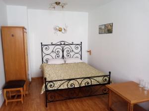 a bedroom with a black bed in a room with a table at Family Hotel Rai in Shumen