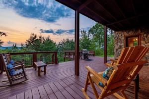 a deck with two rocking chairs on a cabin at NEW! Panorama Mountain View! PET Friendly and GameRoom with Pool Table, Hot Tub, Fireplace and King Bedrooms with Jacuzzi in Sevierville