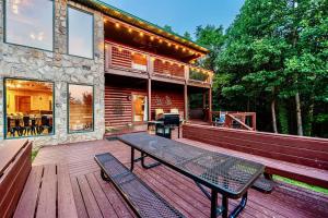 Panorama Mountain View Cabin, Less than 10 miles from Gatlinburg and Dollywood, Dog Friendly, 6 Bedrooms Sleeps 17, Fire Pit, HotTub, Washer Dryer, Fully loaded Kitchen, GameRoom with a TV, Pool Table, Arcade, Air Hockey, and Foosball في سيفيرفيل: سطح خشبي مع طاولة نزهة على المنزل