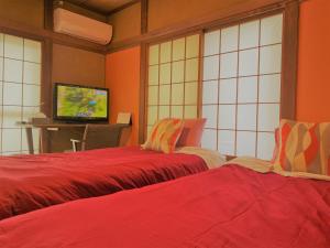 大泉学園ヴィラ في Katayama: غرفة بسريرين وتلفزيون فيها