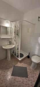 a bathroom with a shower and a toilet and a sink at Aniiza apartman in Örvényes +32 photos