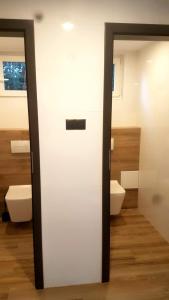een badkamer met 2 toiletten en een witte deur bij Camping nad Warta 