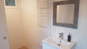een badkamer met een witte wastafel en een spiegel bij Camping nad Warta 
