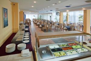 un restaurante con una línea de buffet con comida a la vista en Regina Hotel en Sunny Beach