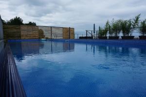 a large swimming pool with blue water at Mandrati Loft in Sarpi