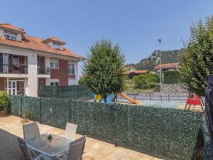 a fence with a table and chairs in front of a pool at Apartamento Holidea El rincón de Arce in Oruña