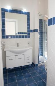 トロペアにあるResidenza Garganoの青いタイル張りのバスルーム(シンク、シャワー付)