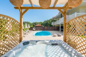 a hot tub in a backyard with a wooden pergola at Villa Montefile in Ialysos