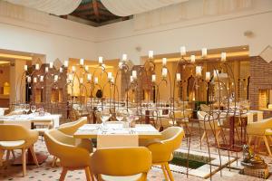 a restaurant with white tables and yellow chairs at Iberostar Selection Marbella Coral Beach in Marbella +37 photos