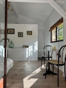 Habitación blanca con mesa y silla. en Chambre d'hôtes Cabanon à 10 min d'Aix-en-Provence en Aix-en-Provence